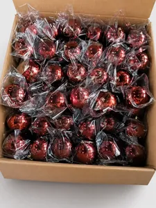 Boules de Noël rouges brillantes en vrac dans un carton pour décoration festive