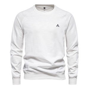 Macro shot of white crewneck sweatshirt detail showing high-quality cotton texture and logo