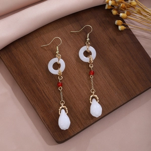 Close-up of Chinese style long tassel earrings with butterfly and drop pearl on wood