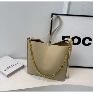 Detail shot of beige PU leather tote bag with thick gold chain and smooth texture