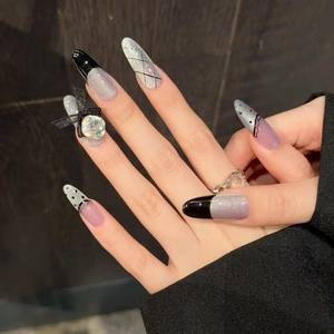 Purple cat-eye press-on nails with black French tips, lace patterns and bow jewelry