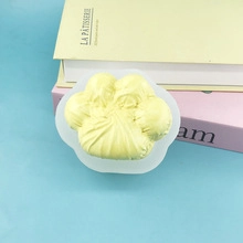 Detailed view of a yellow cat paw shaped silicone mold placed on a transparent stand