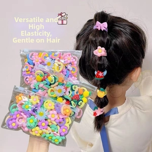 Close-up of elastic cartoon hair ties with fruit and bow charms for girls and toddlers