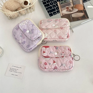 Quilted floral coin purses with zippers shown in a cozy lifestyle desk arrangement
