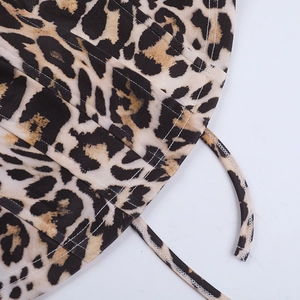 Detail of leopard print fabric with white stitching and thin strap for women's top