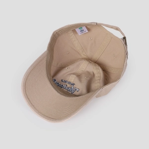 Detail view of cotton baseball cap interior with quality labels and adjustable strap