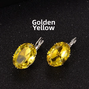 Detailed view of lever-back oval earrings with golden yellow crystals in silver settings