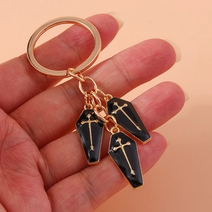 Dark style keychain featuring three black coffin charms with golden crosses on a metal ring