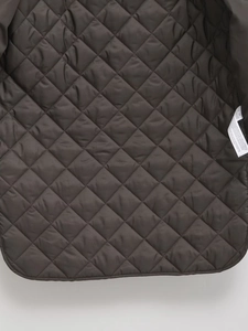 Close-up of quilted diamond texture and care label on dark brown winter coat lining