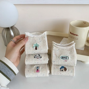 Chaussettes beige en coton avec broderie chien et points colorés en scène cosy