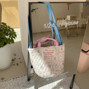 Détail du sac seau matelassé à fleurs avec bandoulière réglable et anses roses