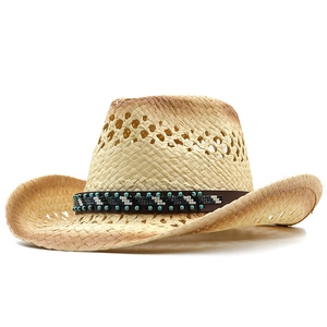 Detail of straw cowboy hat with ethnic beaded band and breathable hollow weave design