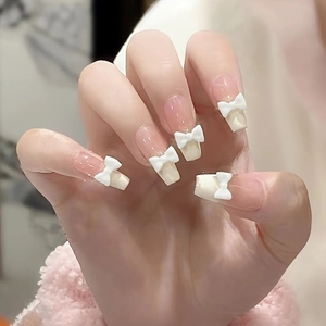 Long square french tip press-on nails with white bows and nude base color