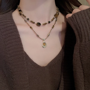 Gros plan d'un collier double rang avec perles et pendentif en ambre irrégulier sur modèle