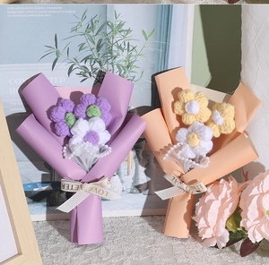 Detailed shot of handmade crochet bouquets with pearls and elegant ribbons in gift wrap