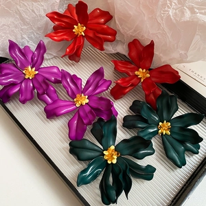 Vibrant matte acrylic flower earrings in red, purple, and green on a clear tray
