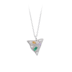 Macro detail of silver triangle pendant with multi-color gemstones and radial texture
