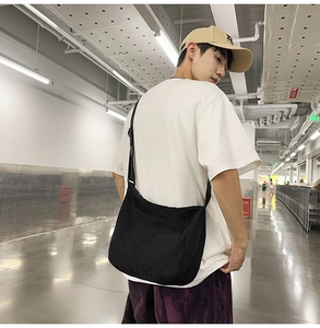 Detail of a black large capacity crossbody messenger bag showing high quality canvas texture