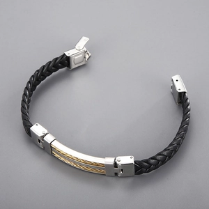 Detail of black woven leather bracelet with stainless steel clasp and gold wire accent