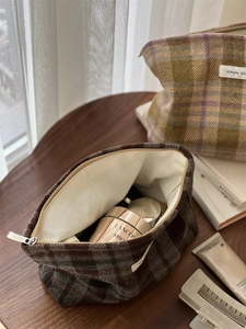 Close-up of vintage brown tweed cosmetic bag showing ample interior storage space