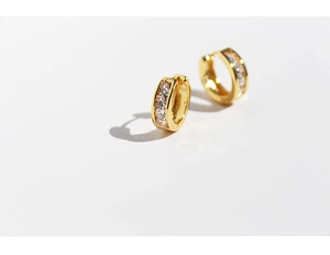 Detailed close-up of golden small hoop earrings featuring row-set white zircon stones