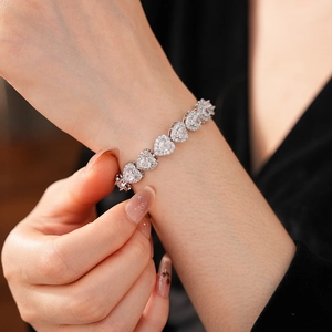 Close-up of a silver heart-shaped tennis bracelet with sparkling cubic zirconia on a wrist