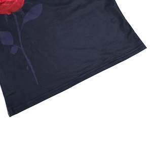 Close-up of the black garment hem featuring a vivid red rose print and double stitching