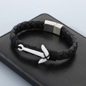 Close-up of anchor charm on black braided leather bracelet with matte magnetic clasp