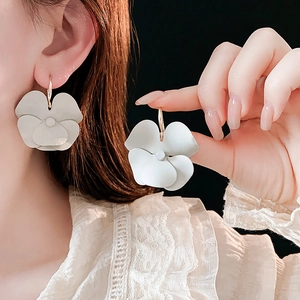 Detailed macro view of matte grey pansy flower earrings with elegant gold hooks