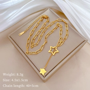 Close-up of gold star pendant necklace with chain tassels on a beige jewelry box