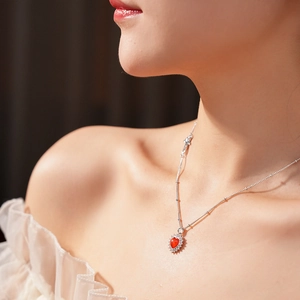 Detail of red heart zircon pendant on S925 silver chain worn by a model
