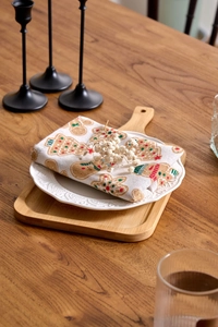 Nahaufnahme einer Leinenserviette mit Lebkuchenmann-Druck auf weißem Keramikteller