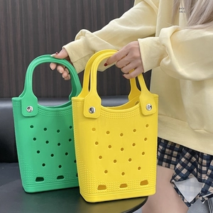 Detail view of colorful green and yellow EVA foam beach bags with waterproof hole pattern