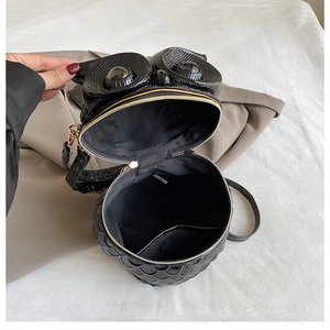 Detail view of the black owl-shaped bag showing interior lining and zipper closure