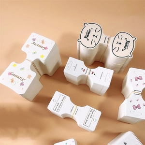 Folded cardboard accessory packaging cards with cute cat, flower, and ribbon designs