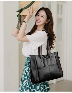 Lifestyle view of large black soft PU leather tote bag worn by a model in casual setting