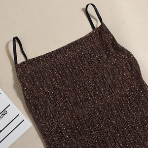 Detailansicht der bronzenen Strass-Stofftextur und der dünnen schwarzen Träger am Kleid