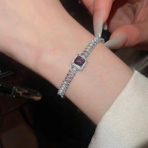 Vue macro d'un bracelet papillon en argent avec zircon violet carré et diamants