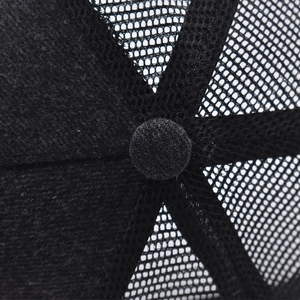 Detalle macro de gorra trucker negra con malla transpirable y textura de la tela
