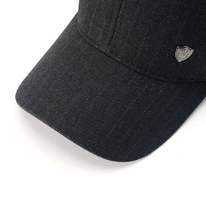 Detail of black winter baseball cap showing white pinstripe texture and silver logo plate