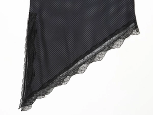 Vue détaillée du tissu à pois noirs avec une bordure en dentelle noire délicate sur le haut