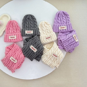 Detail von Zopfmuster und Aufnähern an warmen Kinder Winter Strickmützen und Schal-Sets