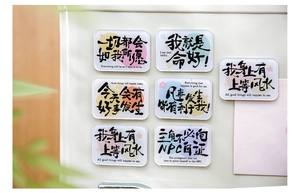 Close-up of 6 acrylic fridge magnets with motivational quotes on a white surface