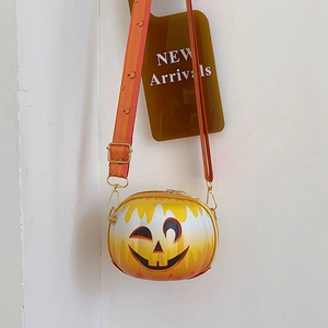 Detail of pumpkin-shaped crossbody bag featuring striped strap and gold metal hardware