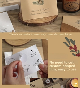 Close-up of vintage kraft paper envelope with pinecone floral greeting card and round stickers