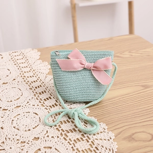 Détail du sac à bandoulière en paille vert menthe avec nœud rose pour les activités de plein air