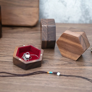 Hexagonal walnut jewelry box with red velvet lining showing a silver necklace detail