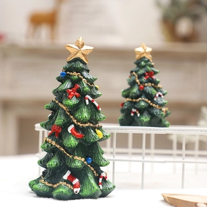 Mini resin Christmas tree ornaments with gold star and colorful baubles on desk