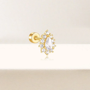 Macro shot of gold S925 silver stud earring with pear-shaped cubic zirconia and halo