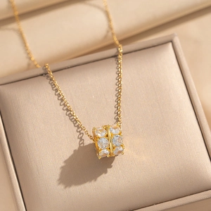 Collana in acciaio al titanio con pendente a cilindro di zirconi in scatola oro champagne